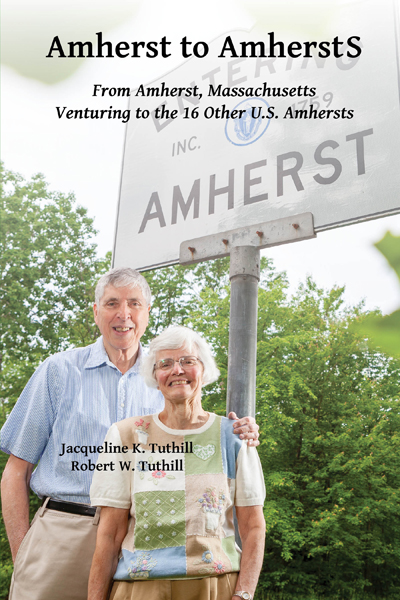Cover photo of the authors in front of road sign reading Welcome to Amherst
